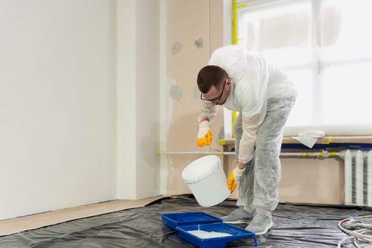 un peintre en batiment verse de la peinture
